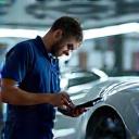 Technician with a checklist inspecting a finished car