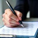 A hand signing an insurance document